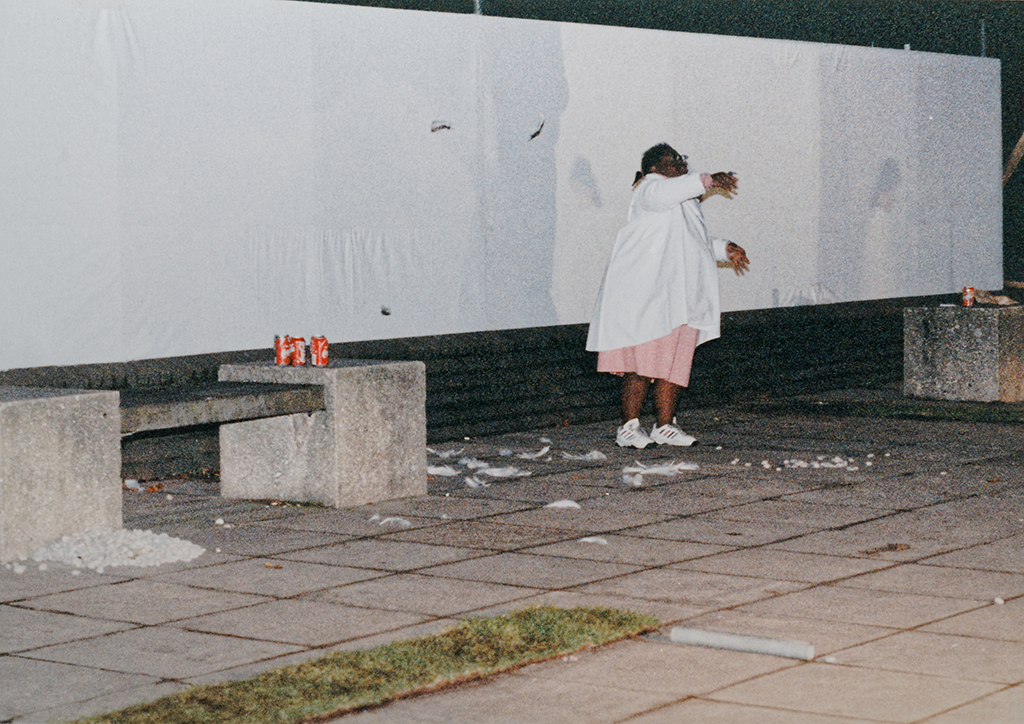 Photo of Natalie dancing outside with feathers in front of projection